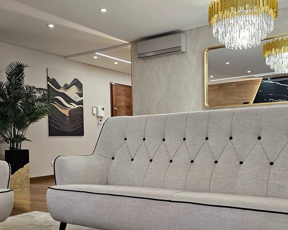 Sala com dois sofás capitonê claros.