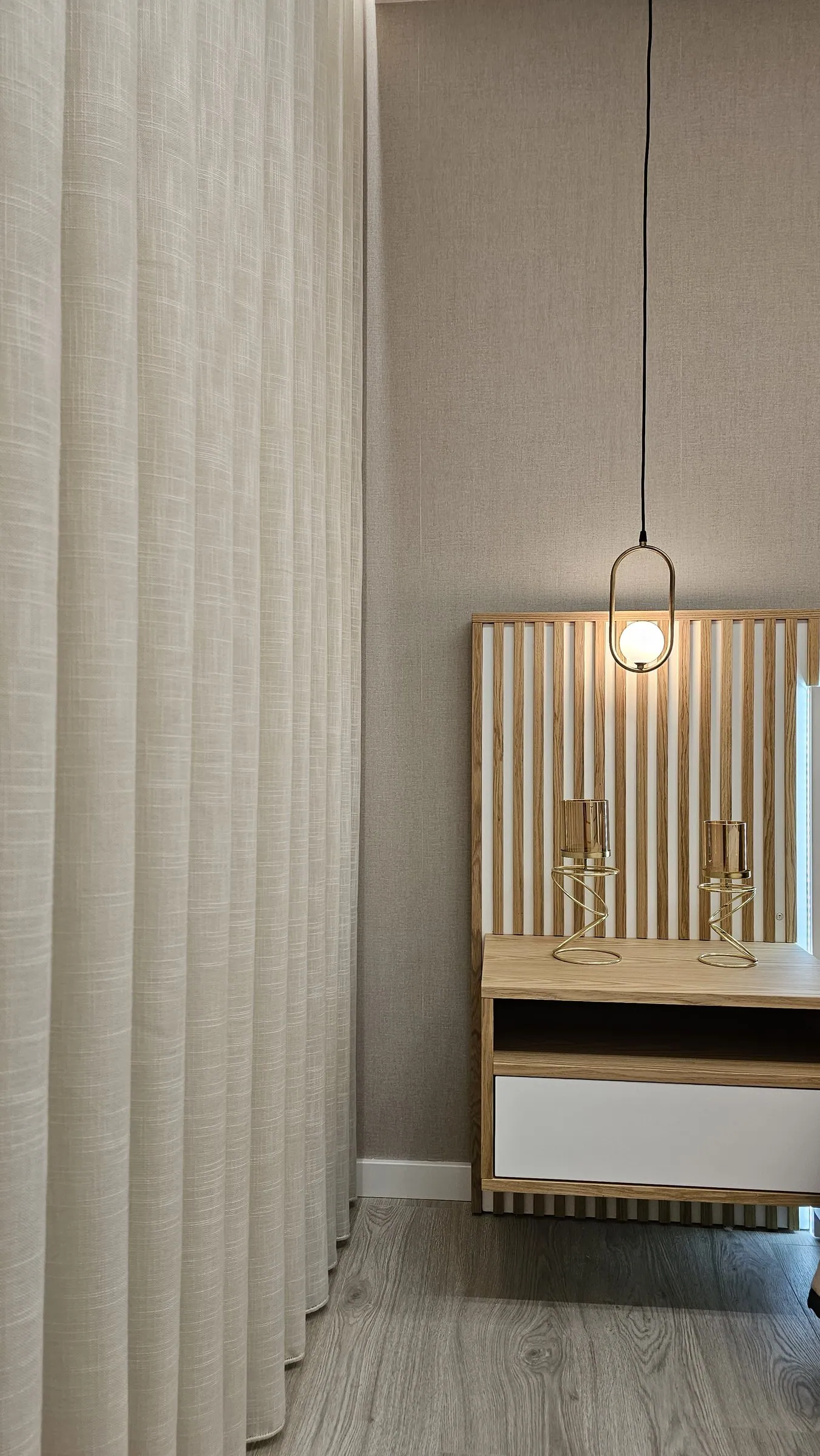 As cortinas até ao chão e a mesa de cabeceira.