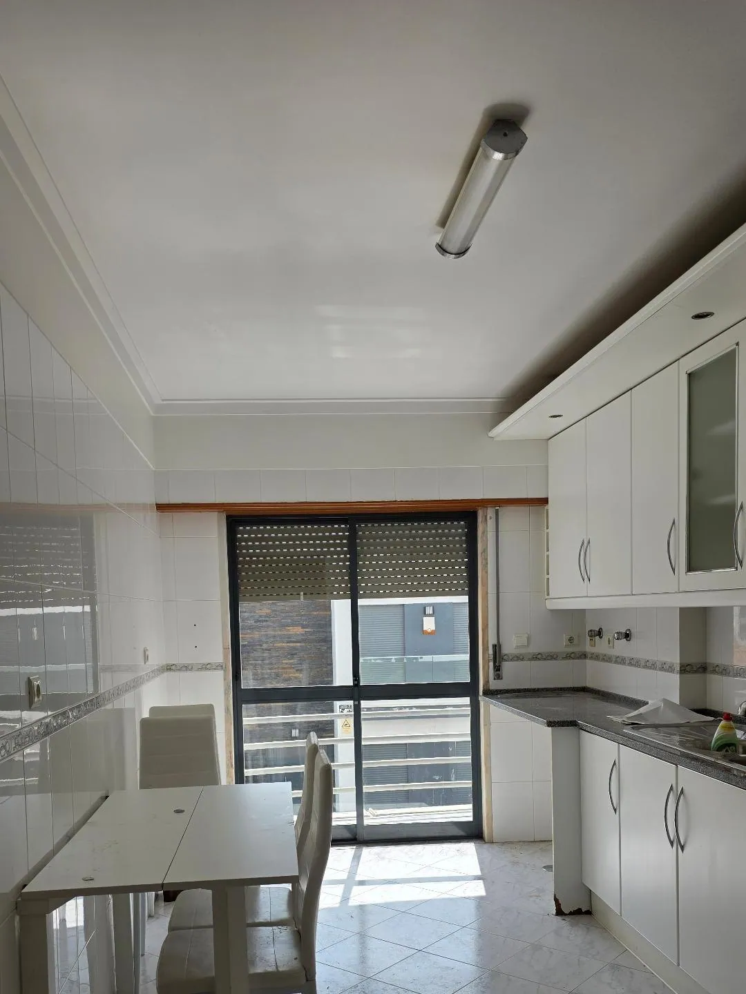 A cozinha antes, com mesa junto à janela.