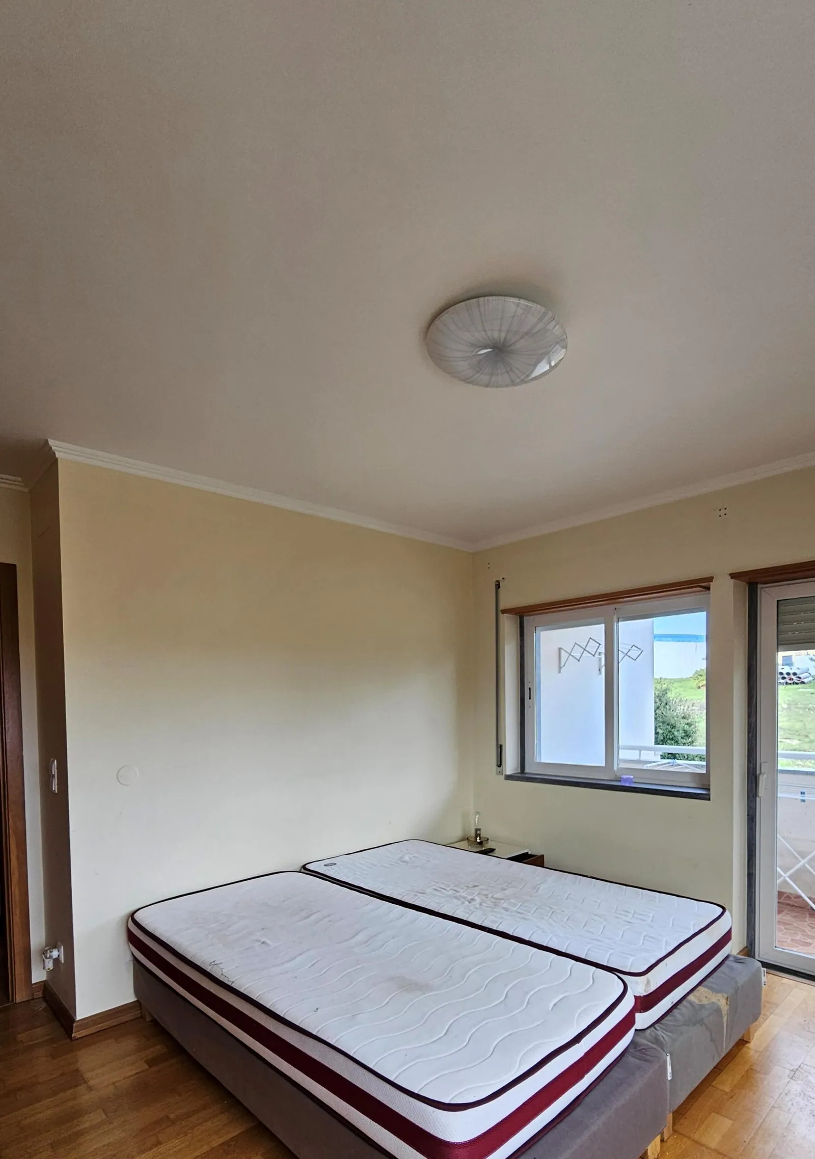 O quarto antes, vazio, com colchões no chão.