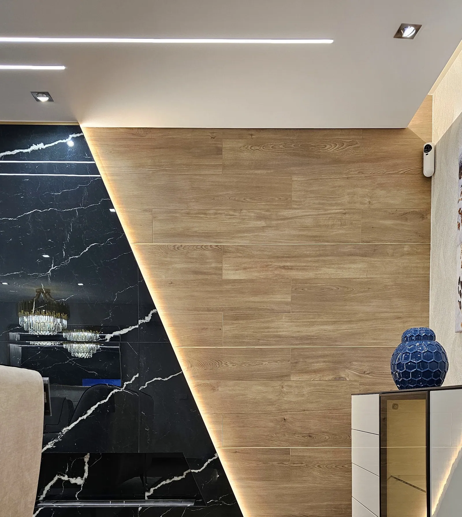 Parede de pedra negra de veio branco ao lado de um painel.