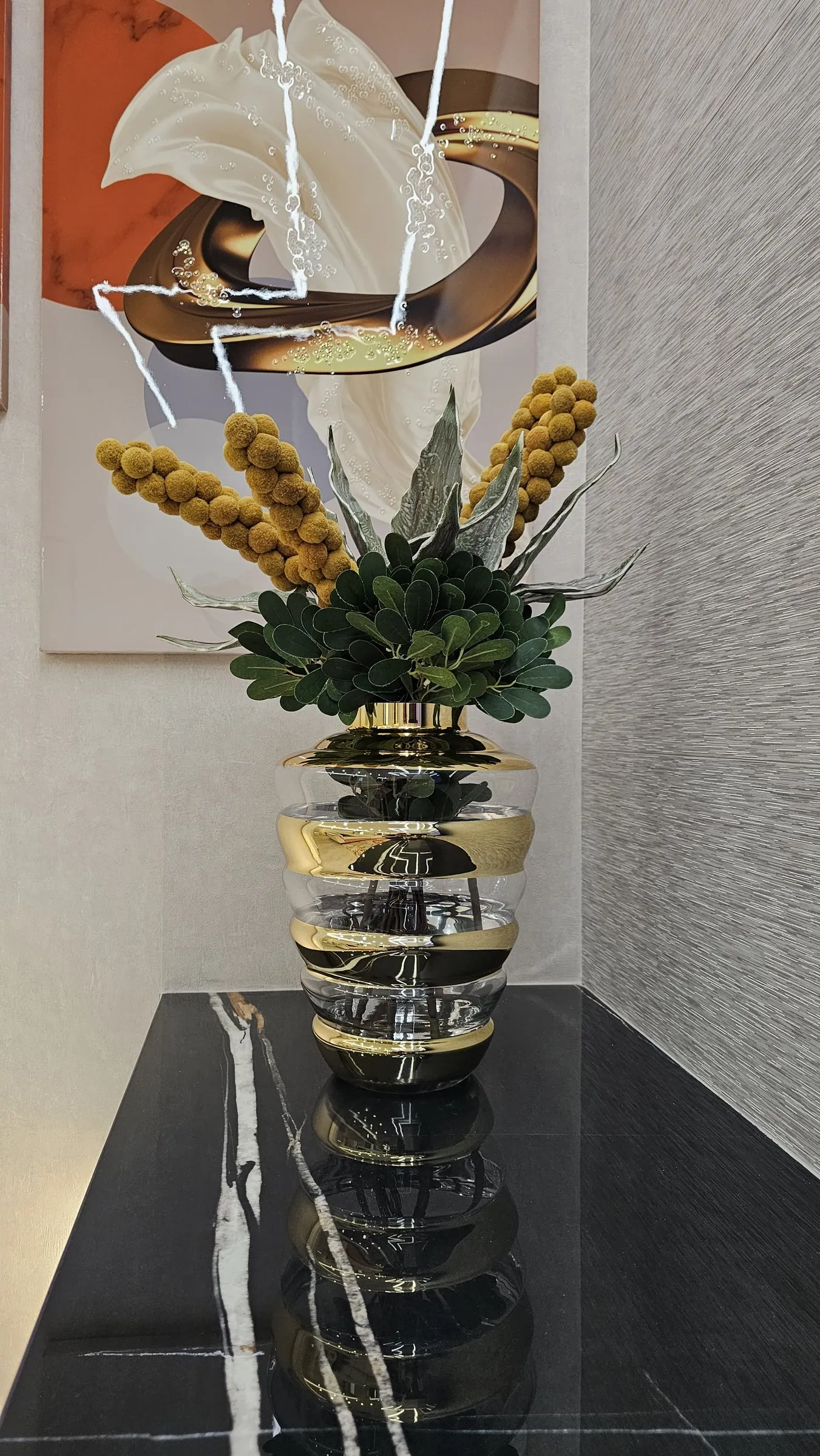 Um vaso sobre o móvel de pedra negra de veio dourado.
