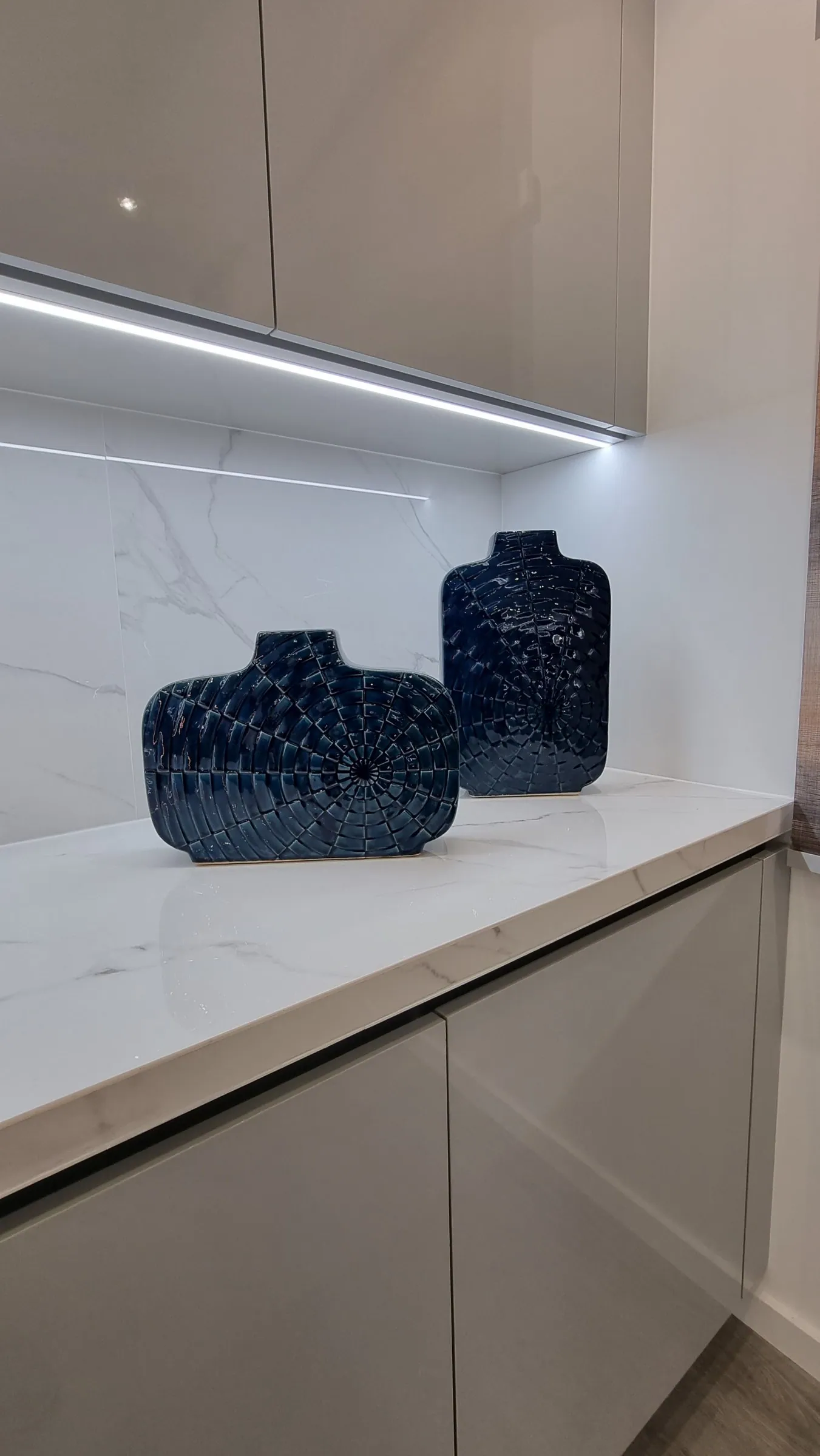 Dois vasos azuis sobre a bancada em pedra.